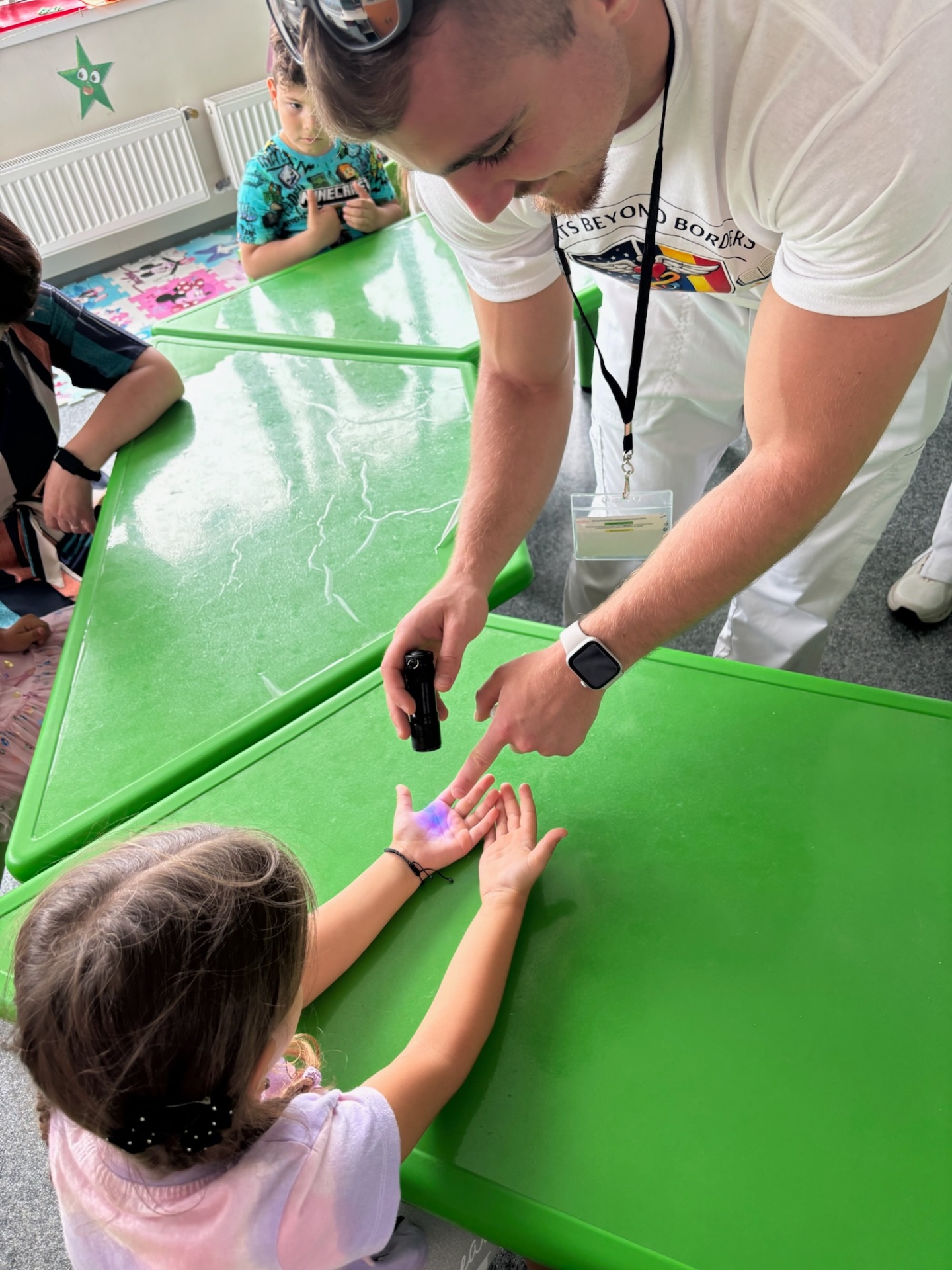 A volunteer demonstrating handwashing with a UV light at the local kindergarten