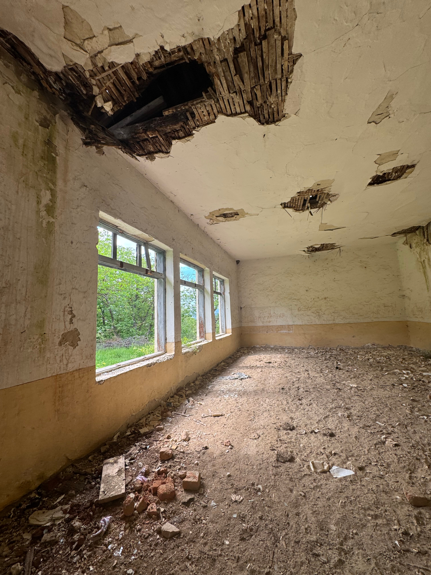 An empty classroom with a caved-in ceiling awaiting restoration